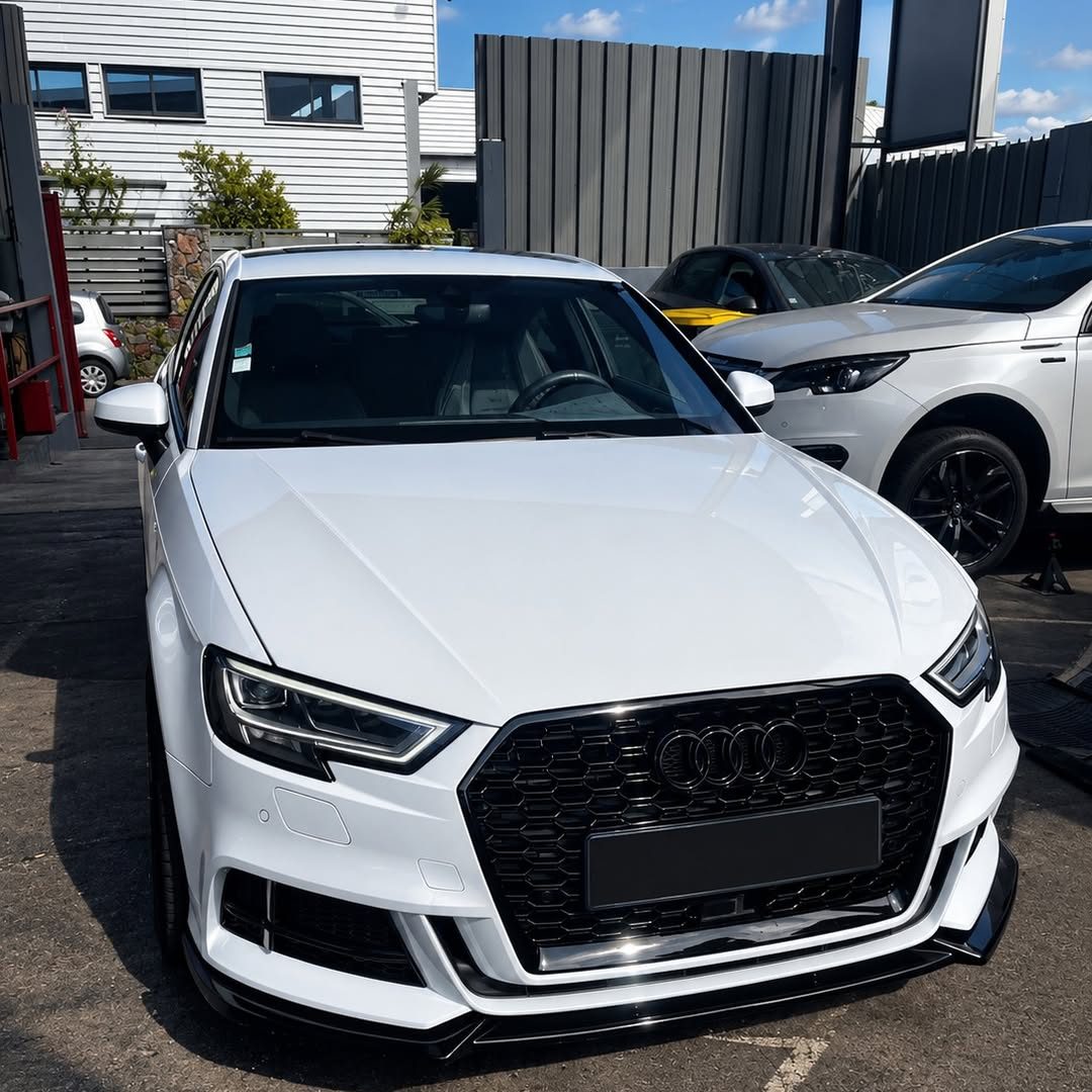Audi A3 blanche devant l'atelier