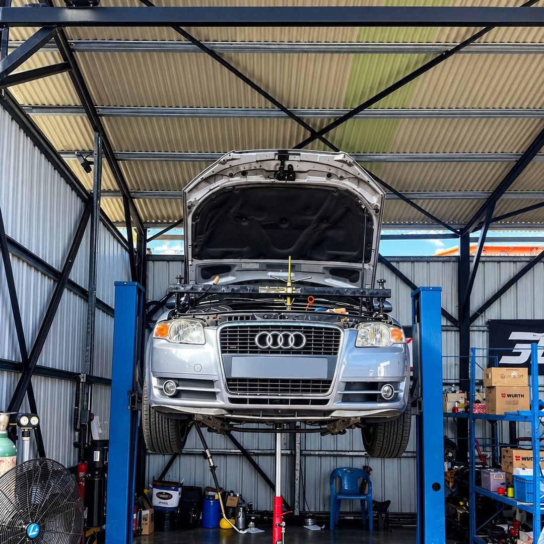 Audi A4 grise sur le pont élévateur, capot ouvert